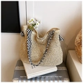Close-up of woven straw tote bag featuring contrast black and white striped handles - Beige Floral Lace Style