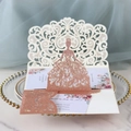 Detail of rose gold laser cut wedding invitation featuring a hollow floral bridal gown - Glitter Champagne Gold