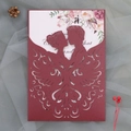 Close-up of laser-cut burgundy wedding invitation with silhouette and floral inner card - Dark Red