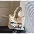 Detail of embroidered 'less Mondays more Sundays' slogan on cream canvas tote bag - Off-white