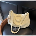 Close-up of pale yellow Hobo bag with metal chain decoration and white bear plush charm - Yellow