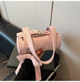 Close-up of pink cylindrical Boston bag featuring large bow and silver buckle detail - Pink