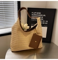 Detail of hand-woven straw tote with brown leather handles and small hanging purse - Khaki