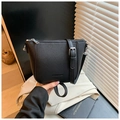 Fashionable black pebble leather bucket bag with silver hardware on a blazer - Black
