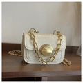 Close-up of cream crocodile pattern bag with gold chain strap and round metallic lock - Off White