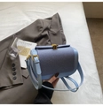 Detail of sky blue leather handbag with dark blue textured fabric and golden shell lock - Blue