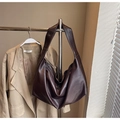 Detail of dark brown leather hobo shoulder bag with natural texture and adjustable strap - Brown