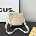 Borsa a secchiello in nylon beige con tracolla larga, ricamo e ciondolo in peluche giallo - Con Ciondolo / Bianco avorio