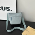 Piccola borsa a secchiello in nylon celeste con tracolla e tasca con zip - senza ciondolo / Blu