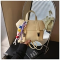 Détail d'un sac à dos en cuir crème avec boucles argentées et breloques colorées - Noir avec pendentif