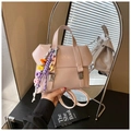 Détail du sac seau rose clair avec breloque lettre arc-en-ciel sur un bureau noir - Rose avec pendentif
