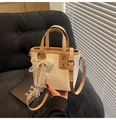 Détail du sac seau crème avec nœud en dentelle, perles et anses en cuir marron - Beige Avec Charme