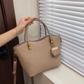 Detail van beige geweven draagtas met goudkleurige hardware en een mini-zakje - Khaki