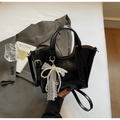 Détail du sac seau en cuir noir brillant avec breloque nœud en dentelle perle et sangle - Noir avec pendentif