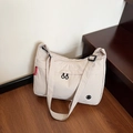 Large beige nylon crossbody bag with wide shoulder strap and red side label for travel - Off White