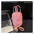 Detailed shot of a pink pebbled leather handbag with smiley tag and silver hardware - Pink