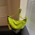 Neon green canvas crescent crossbody bag with adjustable strap on leather sofa - Green