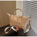 Detail of light beige canvas tote with metal logo and adjustable woven shoulder strap - Off-white