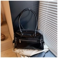 Dettaglio della borsa in pelle nera lucida con zip argento e doppi manici sottili - Taglia unica / Nero