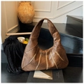 Détail du grand sac hobo en cuir marron foncé avec coutures verticales sur un escalier - Marron