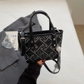 Sac seau rétro noir avec motifs géométriques, poignées en cuir et détail pompon - Noir