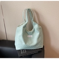 Détail du sac cabas vert clair avec texture gaufrée 3D et étiquette de marque - Vert