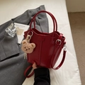 Red patent leather bucket bag with adjustable strap and cute plush bear charm - Burgundy