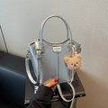 Silver metallic bucket bag with dual handles and cute plush bear charm for styling - Silver