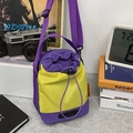 Contrast color bucket bag in purple and yellow nylon with drawstring closure and wide strap - Purple And Yellow