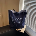 Minimalist navy blue canvas tote bag with white letter print and drawstring closure - Blue