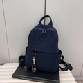 Navy blue nylon backpack with adjustable straps and decorative charm for travel - Dark Blue