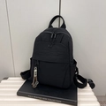 Minimalist black nylon backpack with NMC logo and decorative smiley face strap - Black