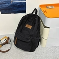 Minimalist black canvas backpack with leather logo patch and large storage capacity - Black