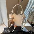 White crocodile-embossed bucket bag with knotted handle and plush bear charm - Beige With Charm