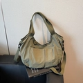 Moss green nylon tote bag with adjustable strap on leather sofa interior setting - Green