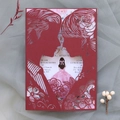 Laser cut wedding invitation detail featuring a romantic couple silhouette and floral lining - Dark Red
