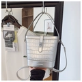 Detail of silver crocodile-embossed bucket bag showing metallic finish and structured handle - Silver