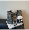Detail of floral tote bag with chain strap, pearl charm, and cloud pendant - Black
