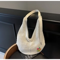 Primer plano del bolso tote de ganchillo blanco con textura de malla y detalle floral - Blanco Roto