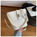Close-up of beige bucket bag with crocodile texture and elegant silver hardware detail - Off-white
