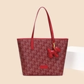 Detail of red tote bag featuring cloud patterns, long straps, and a dog-shaped leather charm - Red