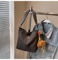 Detail of dark grey canvas bucket bag featuring a plush bear charm and woven orange pendant - Dark Tea Brown (With Charm)