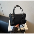 Detail of black lychee grain leather handbag with matching long strap and elephant charm - Elephant Charm Style / Black