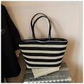 Detail of woven tote bag with black and white stripes and leather handles on suitcase - Black & White Stripes