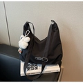 Detail of black crescent canvas bag with texture and white bear plush charm - Black with Pendant