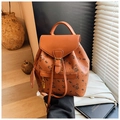 Détail d'un sac à dos marron avec imprimé ours, texture grainée et breloque cadenas doré - Marron