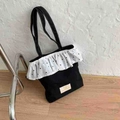 Black canvas tote bag featuring white polka dot ruffle trim and minimalist woven label - Black
