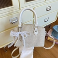 Chic woven straw bucket bag with white leather trim and pearl chain bow detail - Off-white