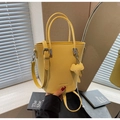 Bright yellow pebbled leather bucket bag with top handles and elephant charm accessory - Yellow