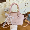 Pink woven bucket bag with lace bow and pearl charm featuring Fashion & Bags logo - Pink